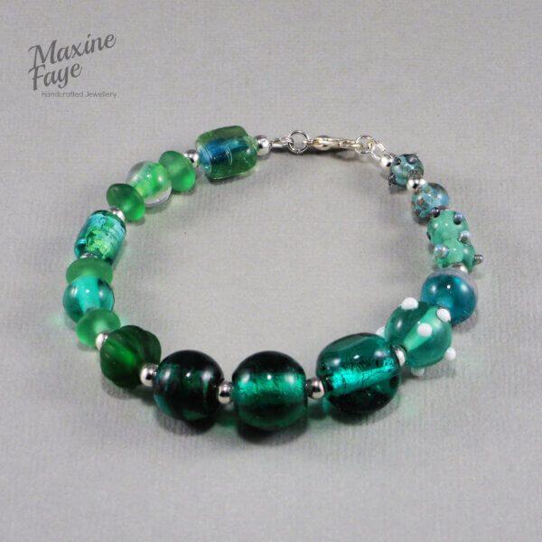 gorgeous lamp-work beads in shades of greens are the feature of this beautiful Teal Green glass bracelet