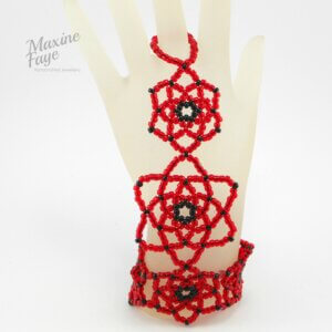 Black and red glass beaded stars stitched together to form the Grace hand-flower bracelet