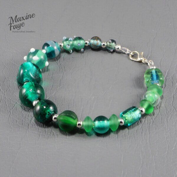 gorgeous lamp-work beads in shades of greens are the feature of this beautiful Teal Green glass bracelet